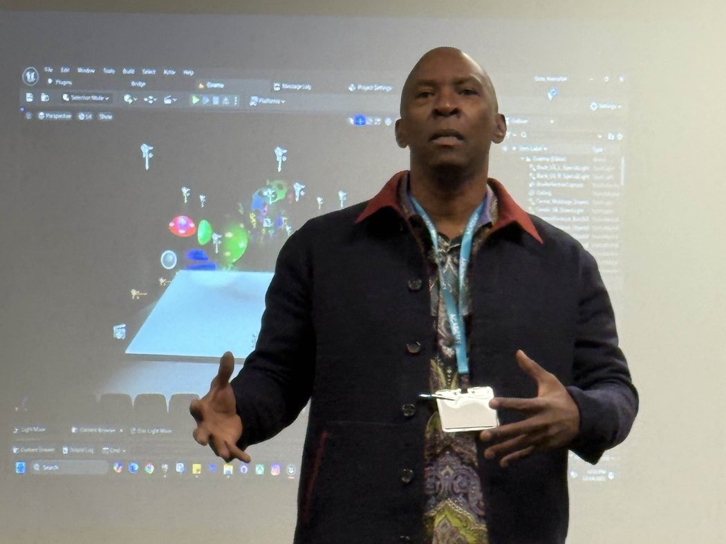 Boris Willis teaching game design in front of a projected Unreal Engine scene