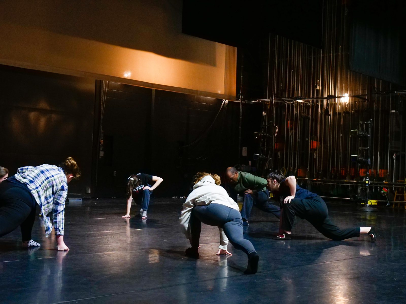 Dancers spaced across the theater stage during a rehearsal run