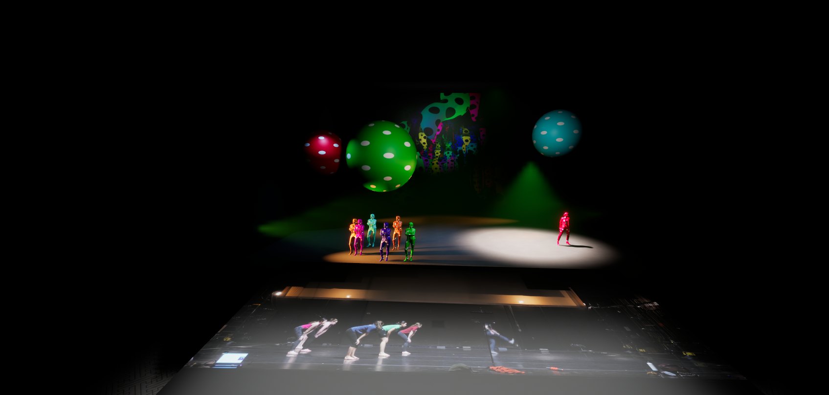 A single red dot-costumed soloist isolated in a spotlight while the rest of the ensemble holds upstage, rehearsal video projected below