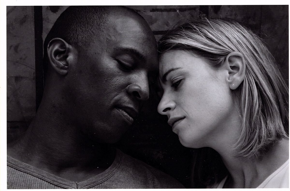 Black-and-white photograph of Boris Willis and Cynthia McLaughlin, cheeks together, eyes closed, in Enter Race