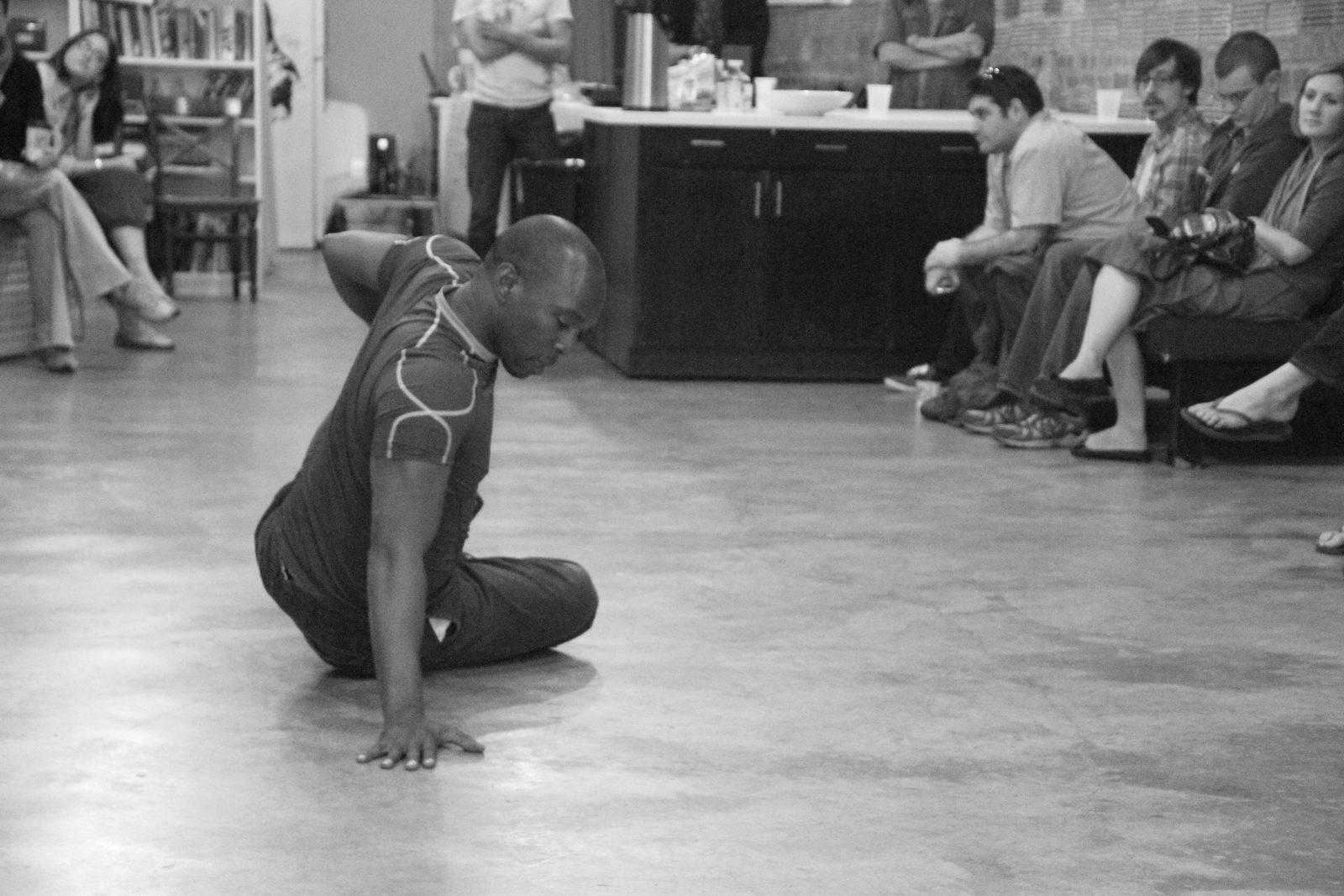 Boris Willis seated on the floor, one hand pressed to the ground