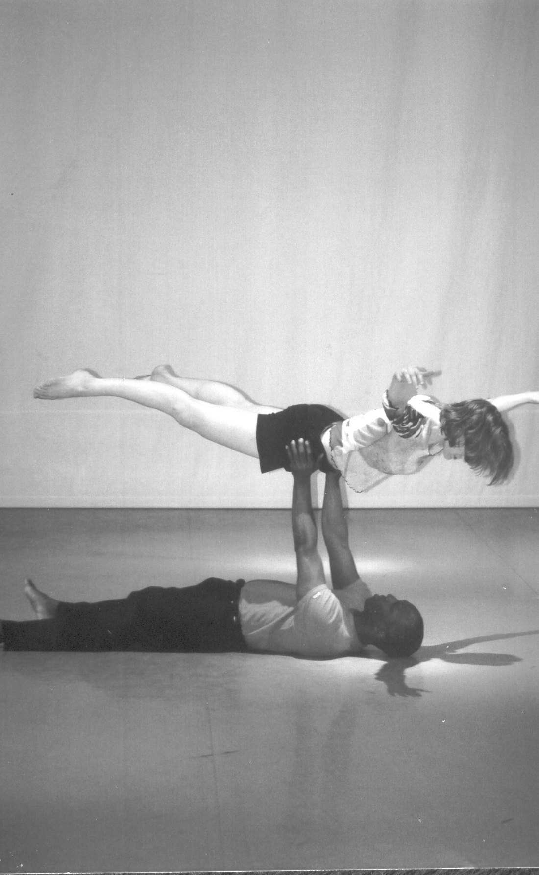 Boris Willis on his back pressing Emily Berry above him in a horizontal lift, Aliens