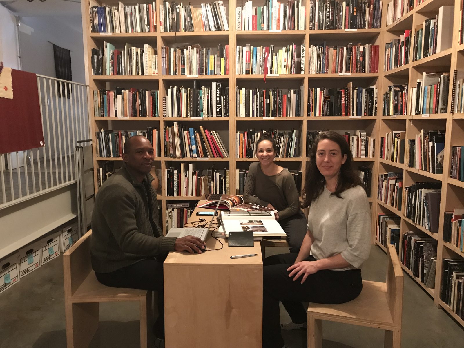 Boris Willis and two collaborators seated at a table in the Watermill Center library