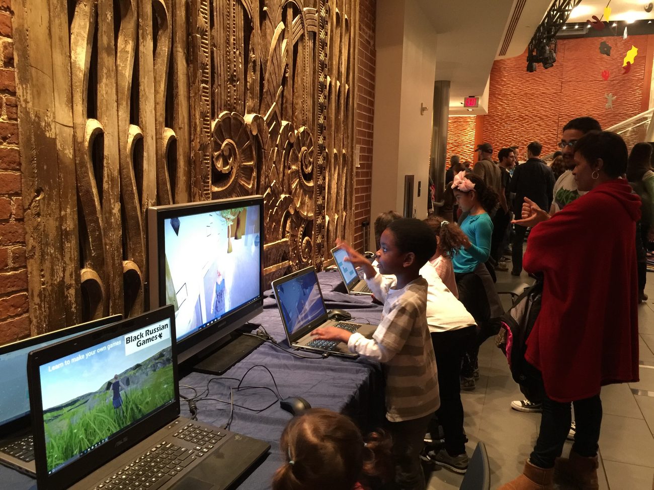 Children playing Natasha on laptops at a public event